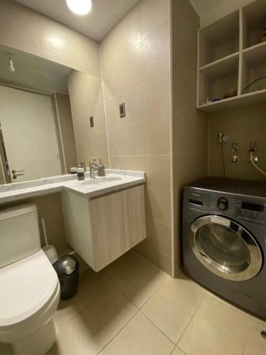 ein Badezimmer mit Toilette und Waschmaschine in der Unterkunft Depto Parque Víctor lamas in Concepción
