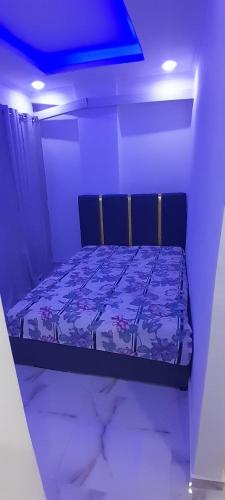 un letto in una stanza con una luce blu di Appartement t2 a Luanda