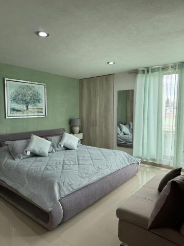 a bedroom with a large bed and a couch at Casa Altavista in Pachuca de Soto