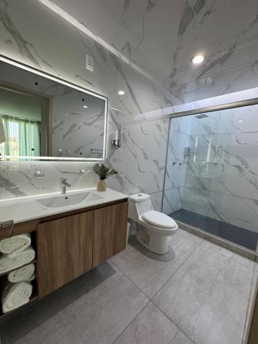 a bathroom with a sink and a toilet and a mirror at Casa Altavista in Pachuca de Soto