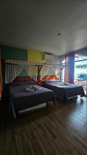 two beds sitting in a room with at Hotel El Rincon de Don Juan in Tecolutla