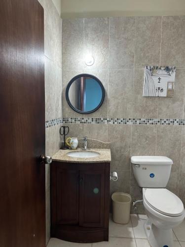 a bathroom with a toilet and a sink and a mirror at Villa Azure in Tower Isle