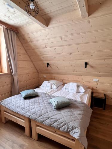 a bedroom with a bed in a log cabin at Żabie Dworki Witów Luxury Chalets & SPA in Witów