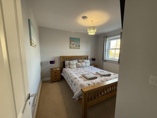 a bedroom with a bed and a window at 12 Green Close at The Bay Filey, sleeps 8, 2 dogs welcome for free too in Filey