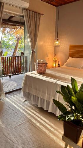 a bedroom with a bed with a table and a balcony at Villa Sairé in Alter do Chao