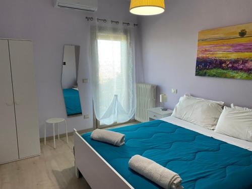 a bedroom with a large bed with blue sheets at Aidone Sunset House in Aidone