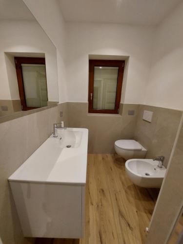 a bathroom with two sinks and a toilet at La cà de Clüsu in Clusone