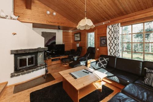 a living room with a couch and a fireplace at Villa Polaris in Äkäslompolo