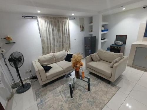 ein Wohnzimmer mit zwei Sofas und einem Tisch in der Unterkunft Résidence Bingerville cité OPES in Bingerville