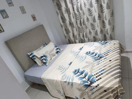 ein Bett mit blau-weißen Laken und Kissen in der Unterkunft Résidence Bingerville cité OPES in Bingerville