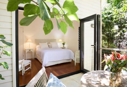 a bedroom with a bed on a balcony at Pittwater Hideaway in Palm Beach