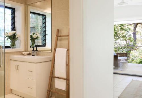 a bathroom with a sink and a ladder next to a window at Pittwater Hideaway in Palm Beach