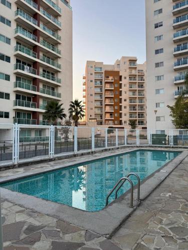a swimming pool in front of some tall buildings at Cozy Loft with Air Conditioning and WiFi near Poliforum Leon Gto in León