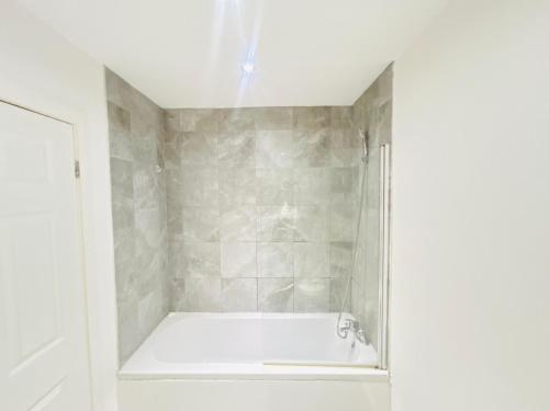 a bathroom with a shower with a bath tub at Doncaster 2 Bedroom Luxury Apartment in Doncaster