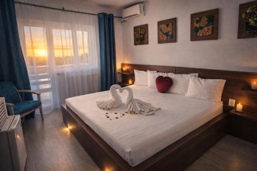 two swans sitting on a bed in a bedroom at Pensiunea Prigoria in Murighiol