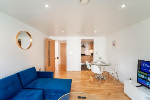 a living room with a blue couch and a table at Cozy 2BR Apt in Greenwich, Near O2 Arena and Excel, Fast Wi-Fi, Free Parking, Excellent links Elizabeth and Southeastern Line in London