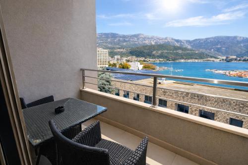 a balcony with a table and chairs and a view of the water at Hotel Butua Residence in Budva