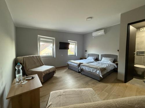 a bedroom with two beds and a couch and a chair at Duplex Oasis Rooms in Ada