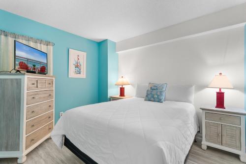 a bedroom with a white bed and blue walls at Oceanfront 1BR Condo with Corner Balcony Pool in Myrtle Beach