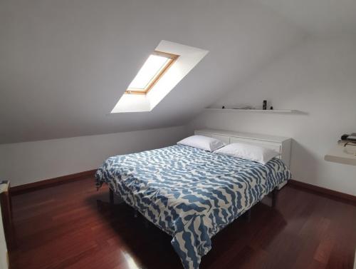 a bedroom with a bed with a blue and white blanket at Atico con terraza al mar in Mogro