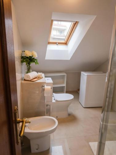 a bathroom with a toilet and a skylight at Atico con terraza al mar in Mogro