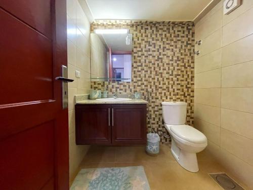 a bathroom with a toilet and a sink and a mirror at Paradise Palms Vacation Rentals in Mīdān az Zīr
