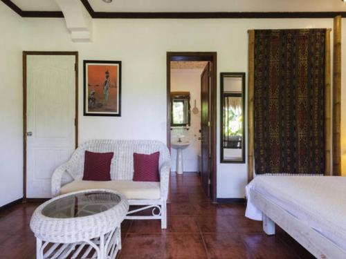 Cette chambre comprend un lit, un canapé et une table. dans l'établissement Lanterna Hotel Boracay, à Boracay