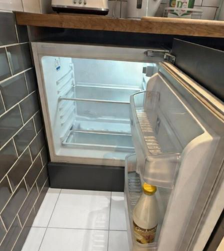 an open refrigerator with a bottle of milk in it at Dreghorn House 5 b-rooms 9 beds 3 toilets 2 showers,1 bath 2 receiption Secure free Parking 233 Wifi in Edinburgh