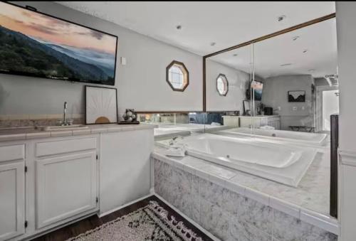 a large bathroom with a tub and a large mirror at Fall Season Mtn Views, Hot Tub, Sauna, close to Downtown! in Gatlinburg