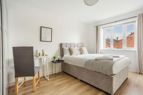 a white bedroom with a large bed and a window at Comfortable 4 Bed Modern Townhouse with Parking in Long Eaton