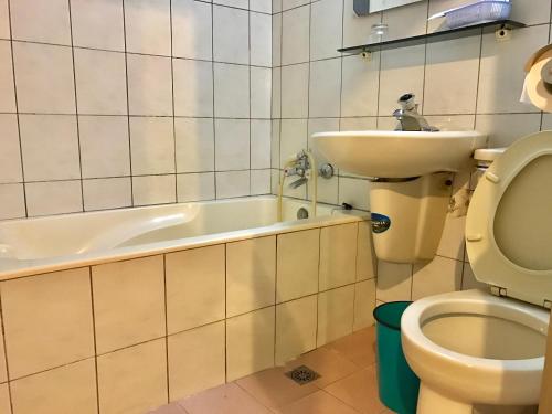 ein Badezimmer mit Badewanne, Waschbecken und Toilette in der Unterkunft Minren Hotel in Yuchi
