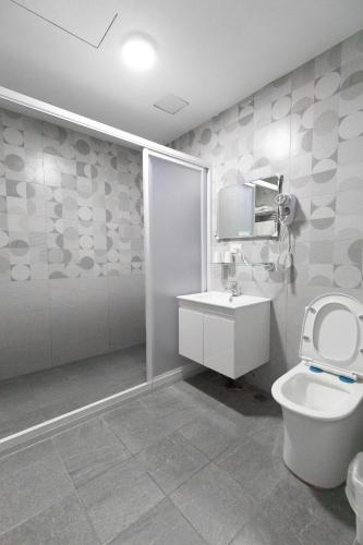 a bathroom with a toilet and a sink and a shower at Home Rest B&B in Lijia
