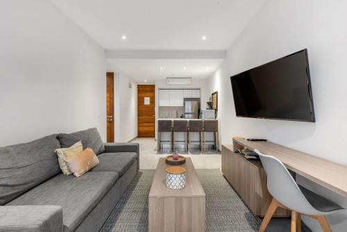 a living room with a couch and a flat screen tv at 2bed apartment 500m from beach in Playa del Carmen