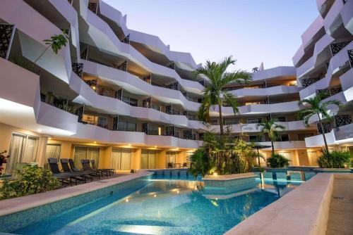 a large apartment building with a swimming pool at Luxury Condo in central location in Playa del Carmen