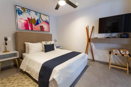 a bedroom with a bed and a flat screen tv at Luxury Condo in central location in Playa del Carmen