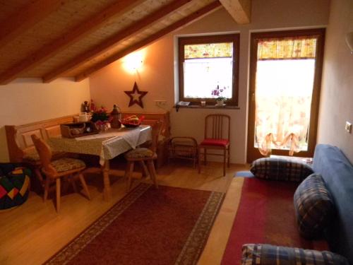 ein Wohnzimmer mit Tisch und Stühlen und zwei Fenstern in der Unterkunft Unterweger Hof in Avelengo