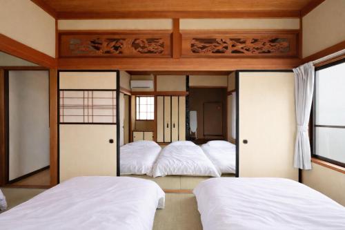 a bedroom with three beds in it at Guesthouse KEN in Toyama