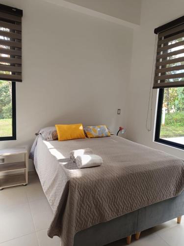 a bedroom with a bed with two towels on it at Avemaría! in Puente Nacional