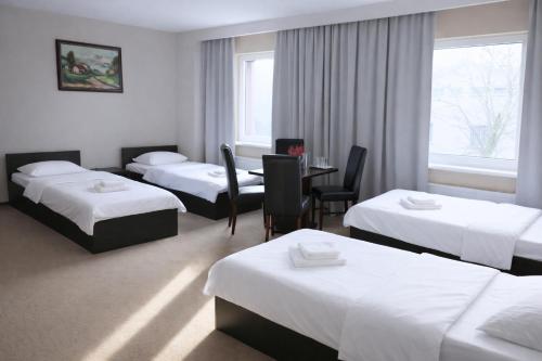 a hotel room with four beds and a table and chairs at Przystanek Słupno, 5 km od Płock in Słupno
