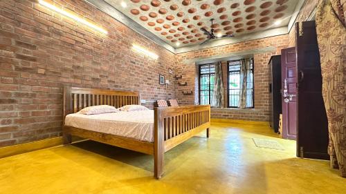 a bedroom with a bed in a brick wall at AV Meadows in Kanchipuram