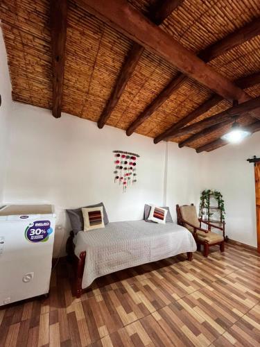 a bedroom with a bed and a refrigerator at Casa campo Ayllu in Tilcara