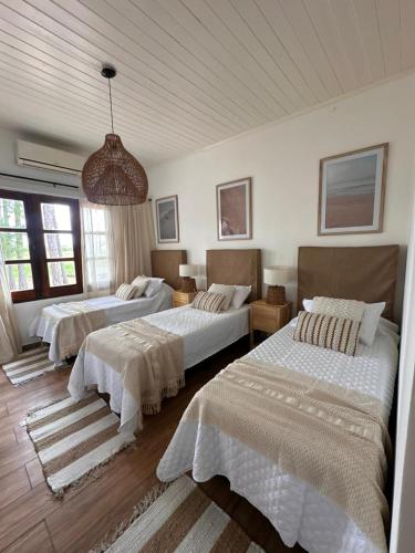 a bedroom with two beds and a chandelier at El Refugio Lodge in Corrientes