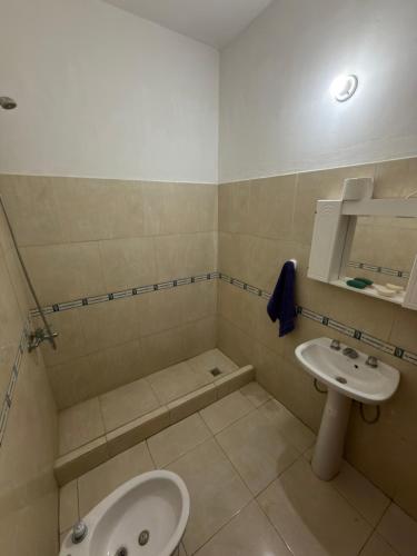 a bathroom with a sink and a tub and a toilet at Apart Sur Catriel in Catriel