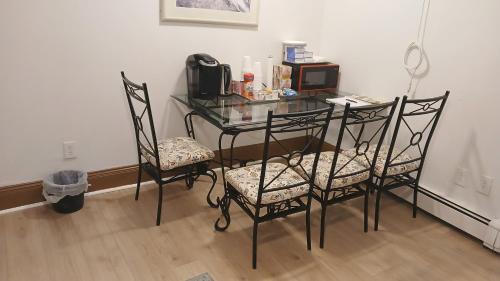 a glass table with two chairs and a phone on it at King-bed room with private bath -FREE WIFI-- New London-Mystic in New London