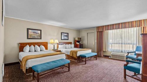 a hotel room with two beds and a window at Red Arrow Inn & Suites, a Travelodge by Wyndham in Montrose