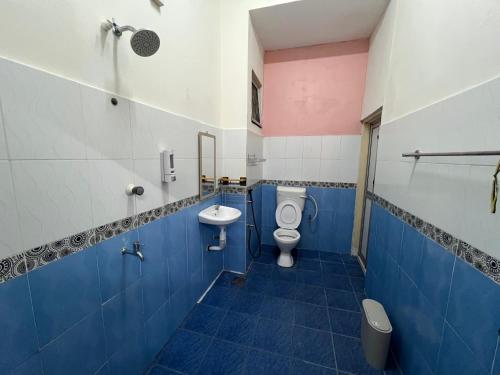 a blue and white bathroom with a toilet and a sink at Homestay Adelia SI in Seri Iskandar