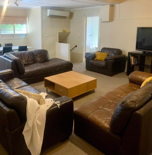 a living room with leather couches and a coffee table at Bacchus Marsh Caravan Park in Bacchus Marsh