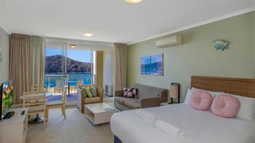 a hotel room with a bed and a living room at Breathtaking - Ettalong Beach Resort in Ettalong Beach