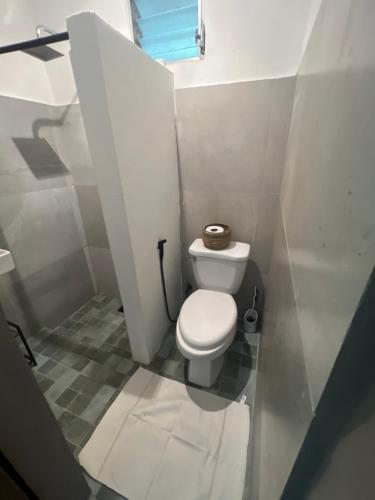 a small bathroom with a toilet and a window at Pumila House in Villa Rosario