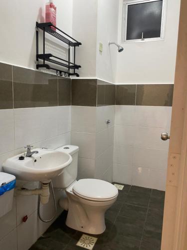 a bathroom with a toilet and a sink at De' Haven Stay - 10minutes to Airport Tawau in Tawau